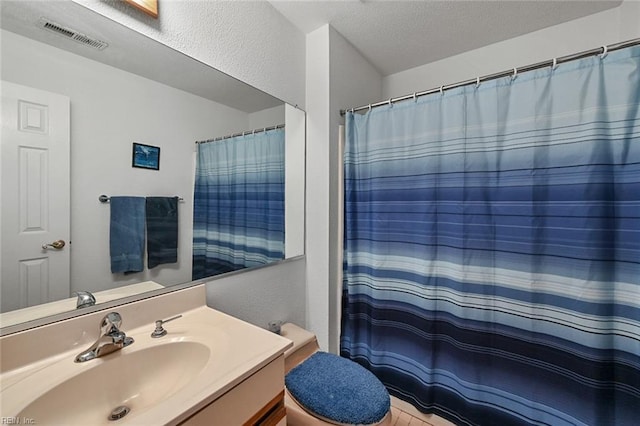 full bathroom with visible vents, toilet, curtained shower, a textured ceiling, and vanity