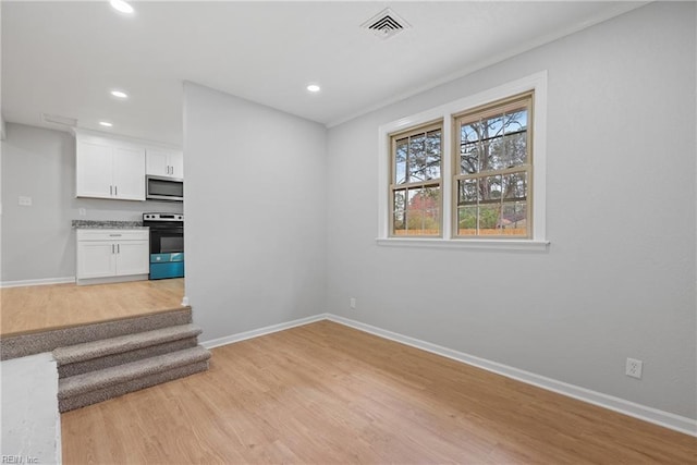 interior space with recessed lighting, visible vents, light wood-style flooring, and baseboards