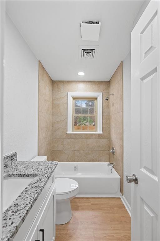 full bath with visible vents, toilet, shower / tub combination, wood finished floors, and vanity