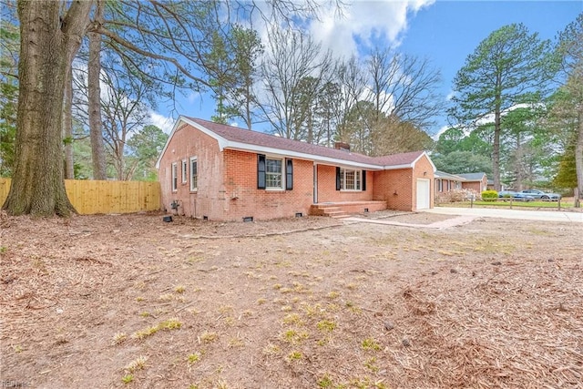 view of front of house with fence, an attached garage, crawl space, brick siding, and a chimney