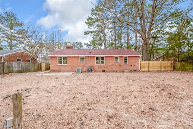 rear view of property featuring crawl space, central air condition unit, brick siding, and a fenced backyard