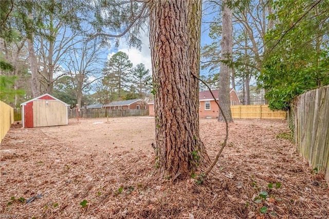 view of yard with a storage shed, an outbuilding, and a fenced backyard