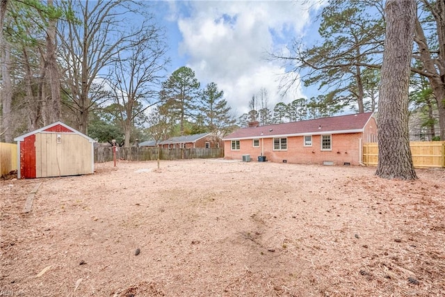 view of yard featuring a storage unit, a fenced backyard, and an outdoor structure