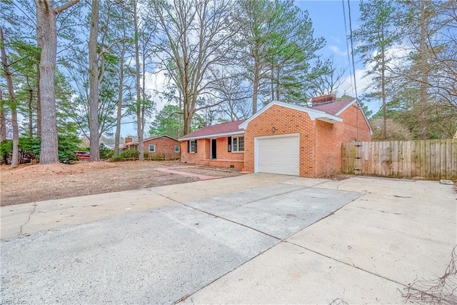 view of front facade with brick siding, fence, concrete driveway, a chimney, and an attached garage