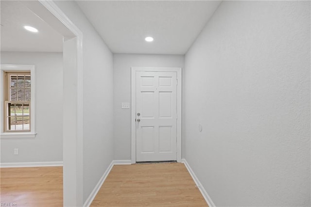 hallway with recessed lighting, light wood-type flooring, and baseboards