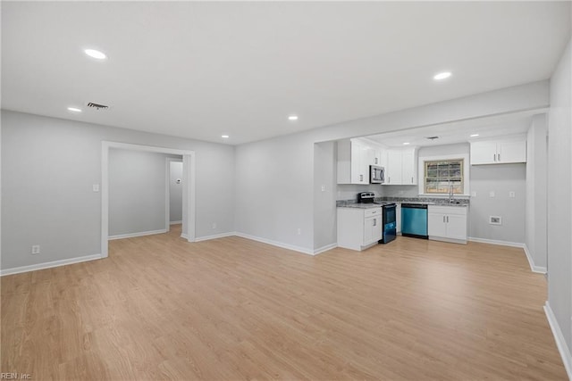 unfurnished living room featuring recessed lighting, visible vents, baseboards, and light wood-style floors