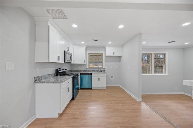 kitchen with stainless steel microwave, visible vents, dishwashing machine, range with electric stovetop, and a sink