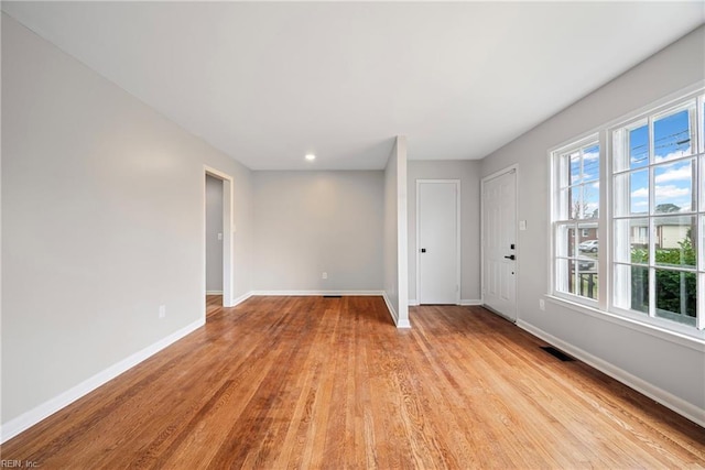 spare room with visible vents, baseboards, and light wood finished floors