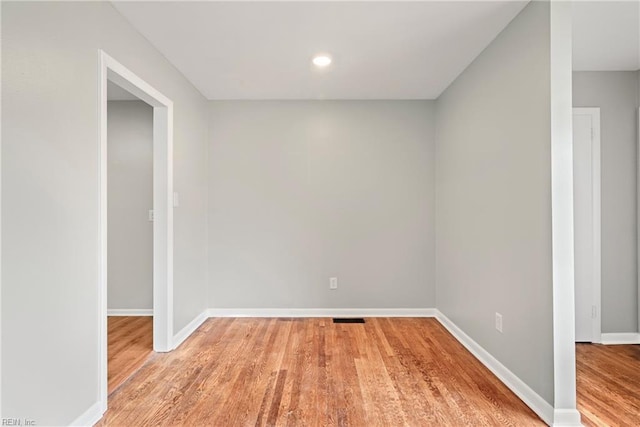 unfurnished room with visible vents, recessed lighting, light wood-type flooring, and baseboards