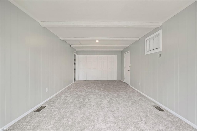 interior space featuring visible vents, beamed ceiling, baseboards, and carpet floors