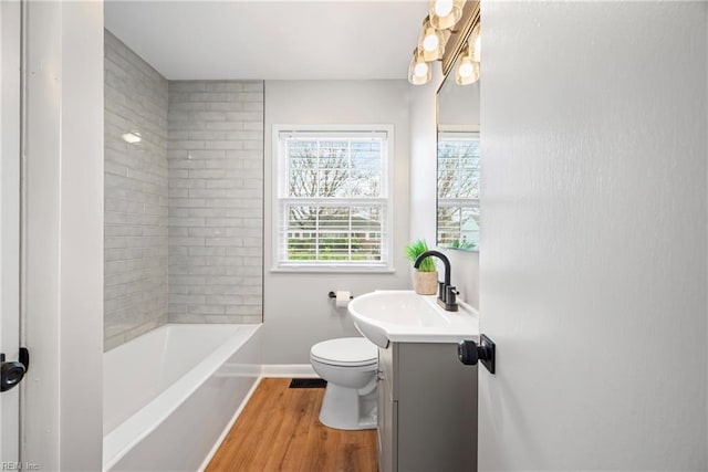 full bath featuring toilet, vanity, baseboards, and wood finished floors