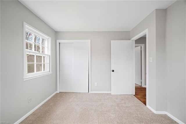 unfurnished bedroom with a closet, baseboards, and carpet