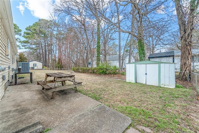 view of yard featuring an outdoor structure, a fenced backyard, a shed, and a patio area