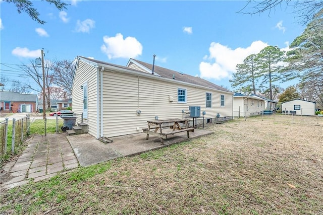 rear view of house with a yard, a fenced backyard, cooling unit, and a patio