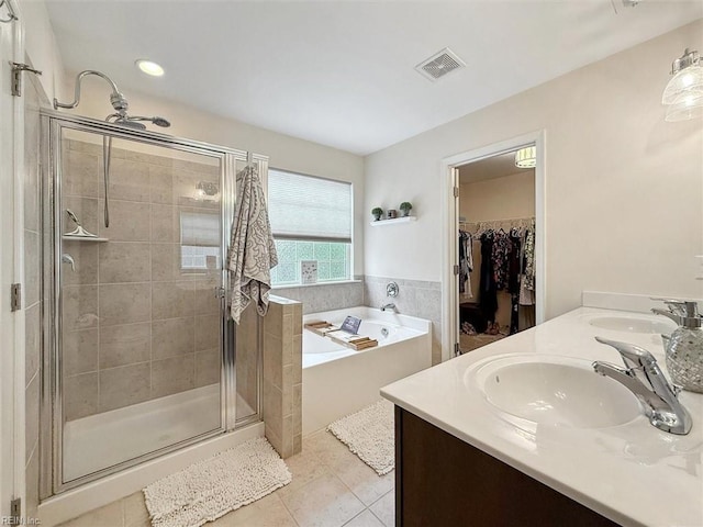 bathroom featuring tile patterned floors, a stall shower, visible vents, and a sink