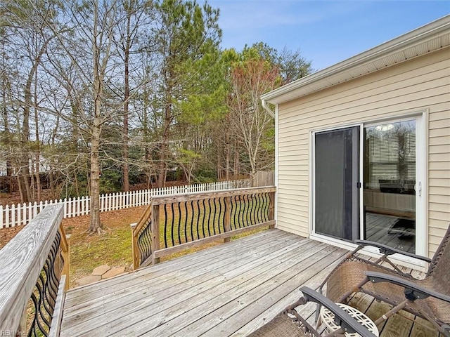 wooden terrace with a fenced backyard