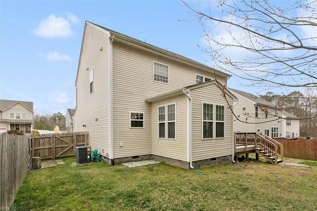 back of house with crawl space, a lawn, cooling unit, and a fenced backyard