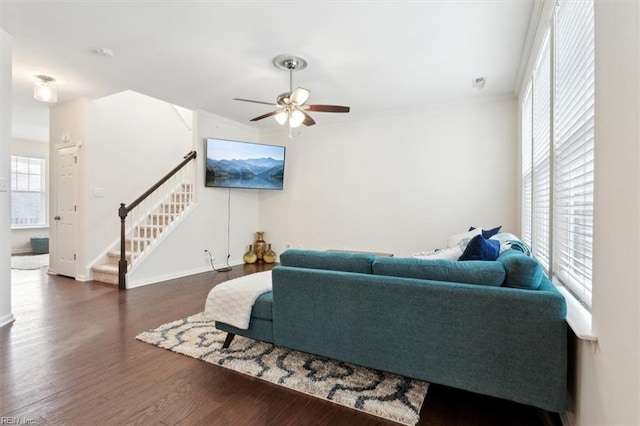 living area featuring stairway, wood finished floors, a ceiling fan, and ornamental molding