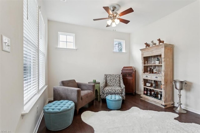 living area with plenty of natural light, wood finished floors, and ceiling fan