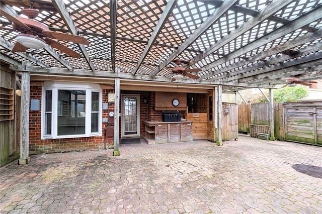 view of patio / terrace with a pergola, exterior kitchen, and fence