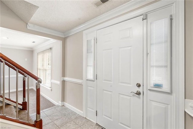 entrance foyer with visible vents, ornamental molding, a textured ceiling, stairway, and light tile patterned floors