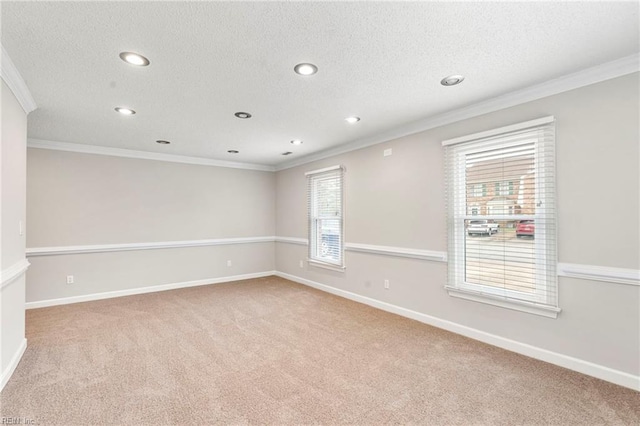 carpeted empty room featuring recessed lighting, a textured ceiling, crown molding, and baseboards