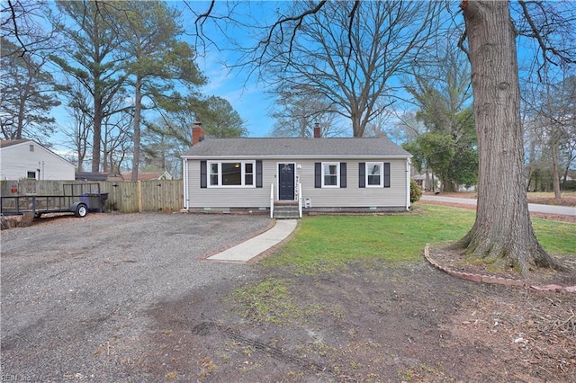 view of front facade with crawl space, a chimney, a front yard, and fence