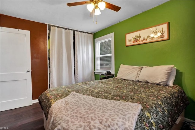 bedroom with a ceiling fan, wood finished floors, and baseboards