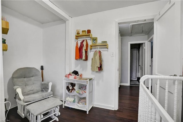 interior space featuring attic access, wood finished floors, and baseboards