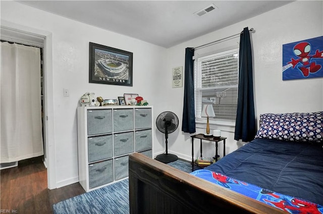 bedroom featuring visible vents, baseboards, and wood finished floors