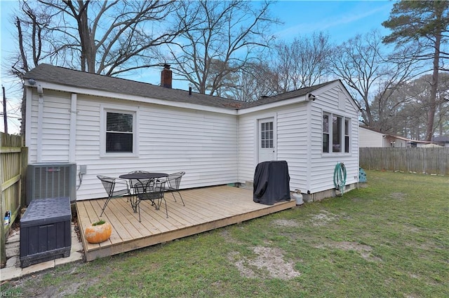 rear view of property with a lawn, central AC, a fenced backyard, a wooden deck, and a chimney