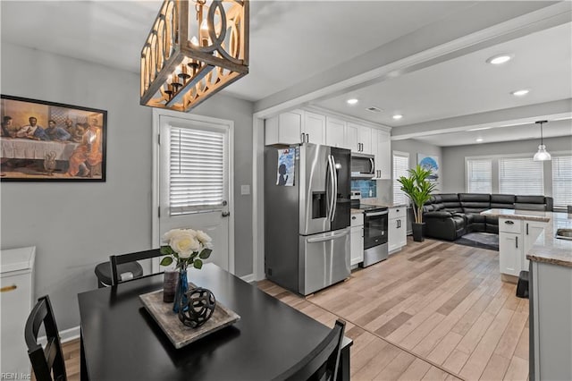 dining room with beam ceiling, recessed lighting, light wood-style floors, and baseboards