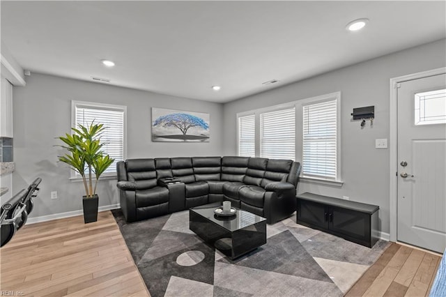 living room featuring recessed lighting, baseboards, and light wood finished floors