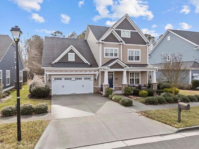 craftsman-style house with stone siding, covered porch, and driveway