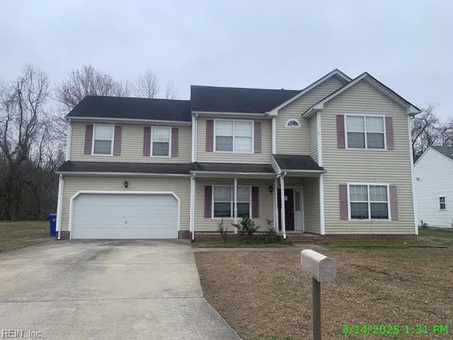 view of front of home with a garage, a front yard, and driveway