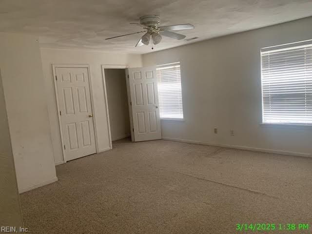 spare room with light colored carpet, baseboards, and ceiling fan