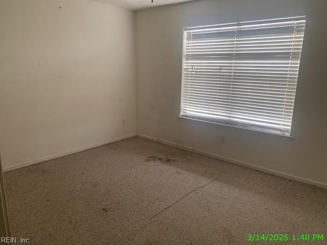 unfurnished room with baseboards and carpet floors