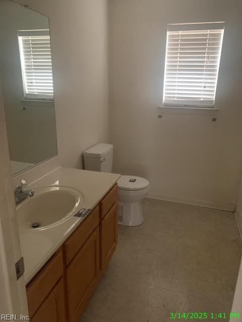 bathroom with tile patterned floors, baseboards, toilet, and vanity