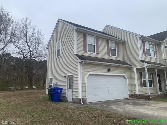 view of side of home featuring a lawn, driveway, and a garage