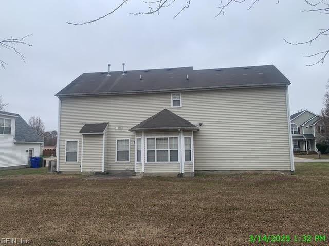 back of property featuring a yard