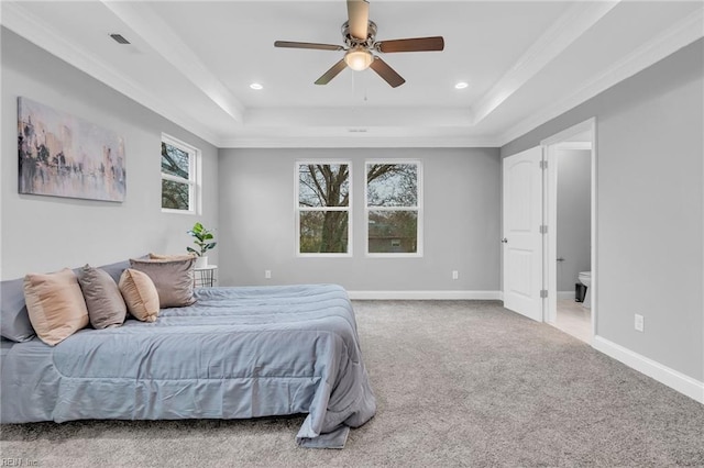 bedroom with a tray ceiling, baseboards, carpet floors, and ornamental molding