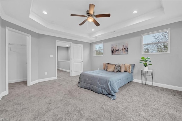 bedroom with a tray ceiling and baseboards