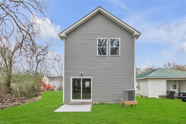 back of property with central air condition unit and a yard