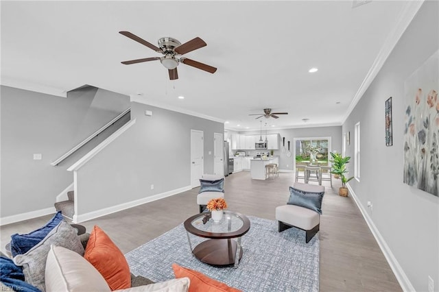 living room with baseboards, stairs, and ceiling fan