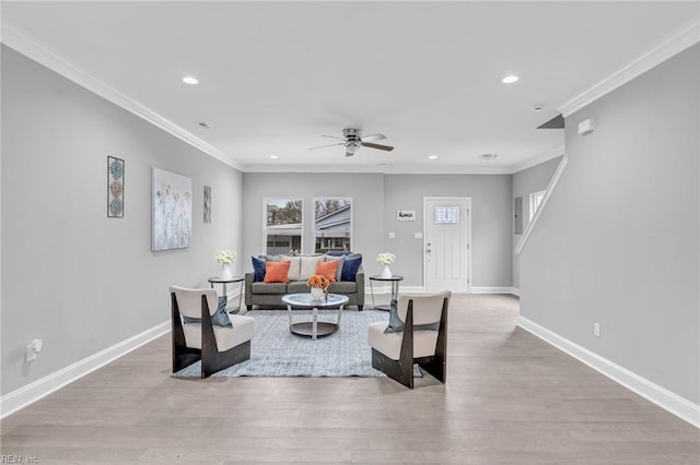 living area featuring wood finished floors, baseboards, recessed lighting, ornamental molding, and ceiling fan