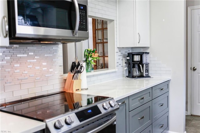 kitchen featuring white cabinetry, light countertops, backsplash, and appliances with stainless steel finishes