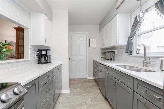 kitchen featuring a sink, gray cabinetry, light countertops, appliances with stainless steel finishes, and white cabinetry