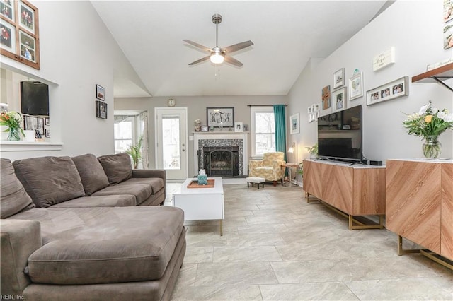 living room with high vaulted ceiling, ceiling fan, and a tile fireplace