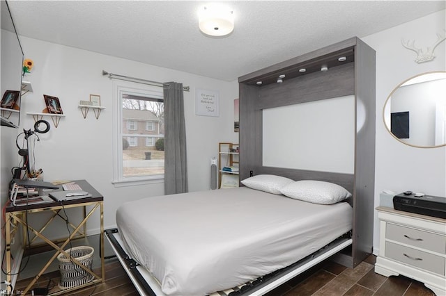 bedroom with a textured ceiling and wood tiled floor