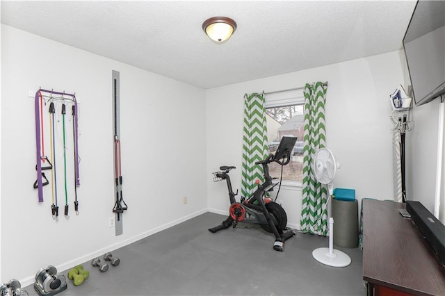 exercise area with a textured ceiling and baseboards